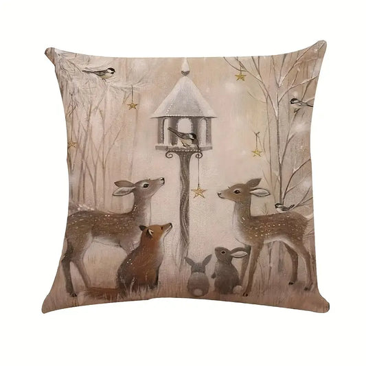 Winter pillow cover featuring deer and woodland animals gathered in a winter forest scene with bird feeder.