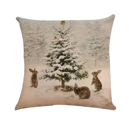Winter pillow cover featuring snowy pine tree and rabbits in a winter forest scene.