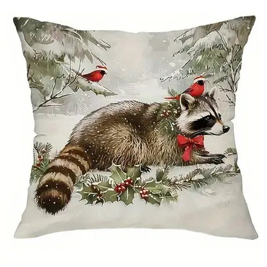 Winter pillow cover featuring a raccoon in a snowy woodland setting with winter greenery and red berry accents.