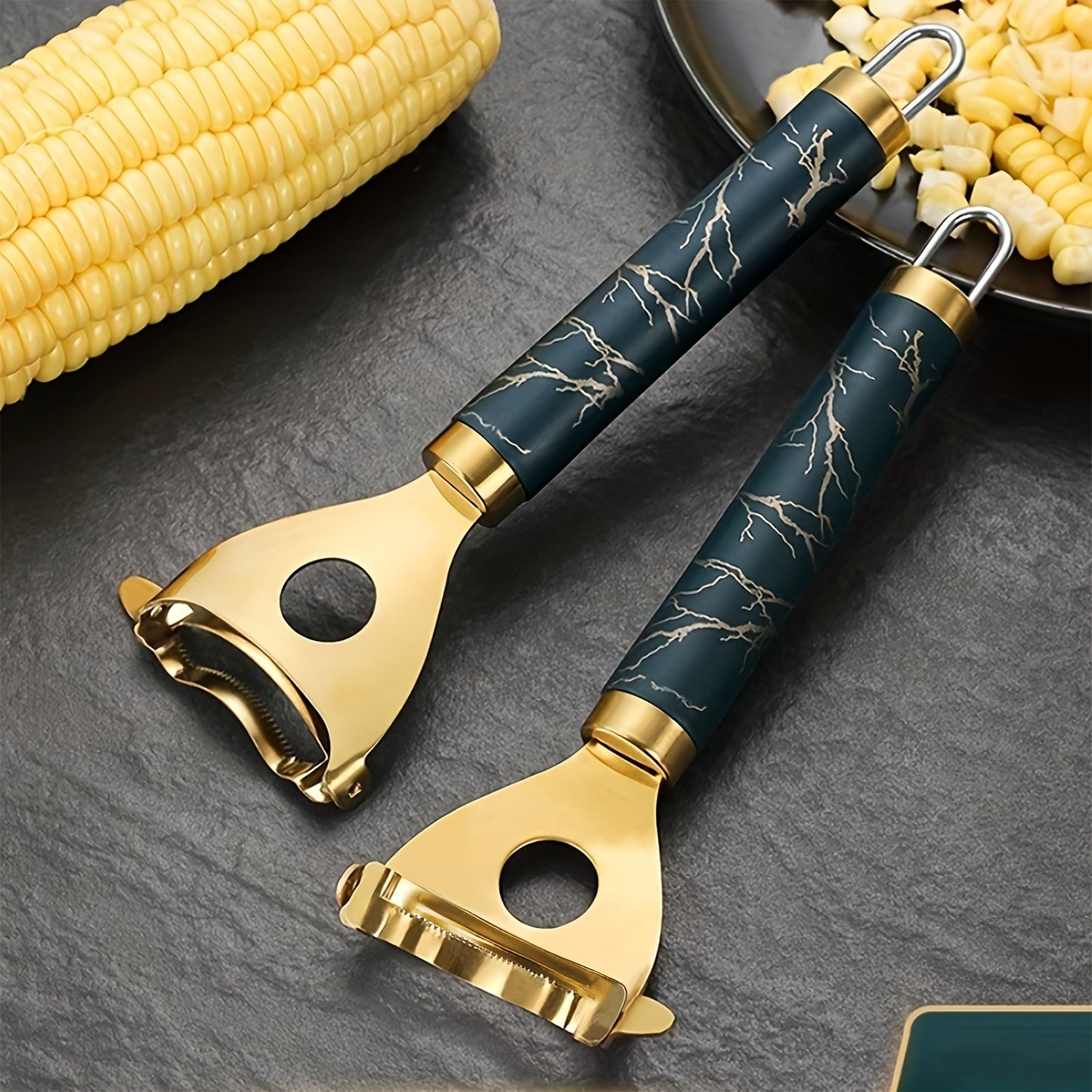 Heavy-duty gold-tone corn stripper featuring a navy marble-patterned handle for a functional and sophisticated kitchen décor.
