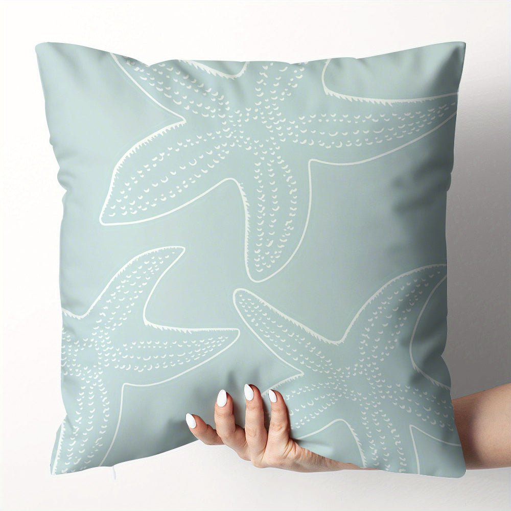 Light blue pillow with white starfish pattern held by a hand against a neutral background